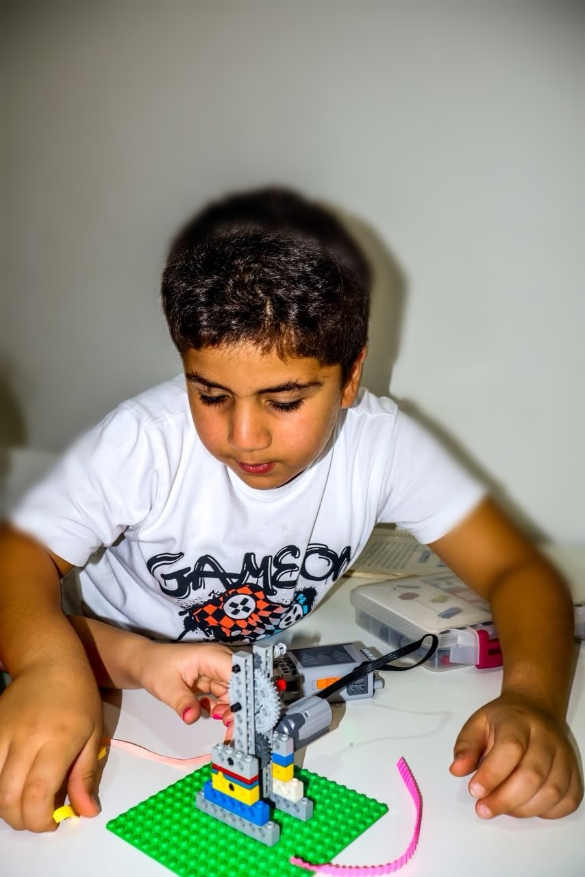 A learner concentrating as he builds a motorised LEGO crane