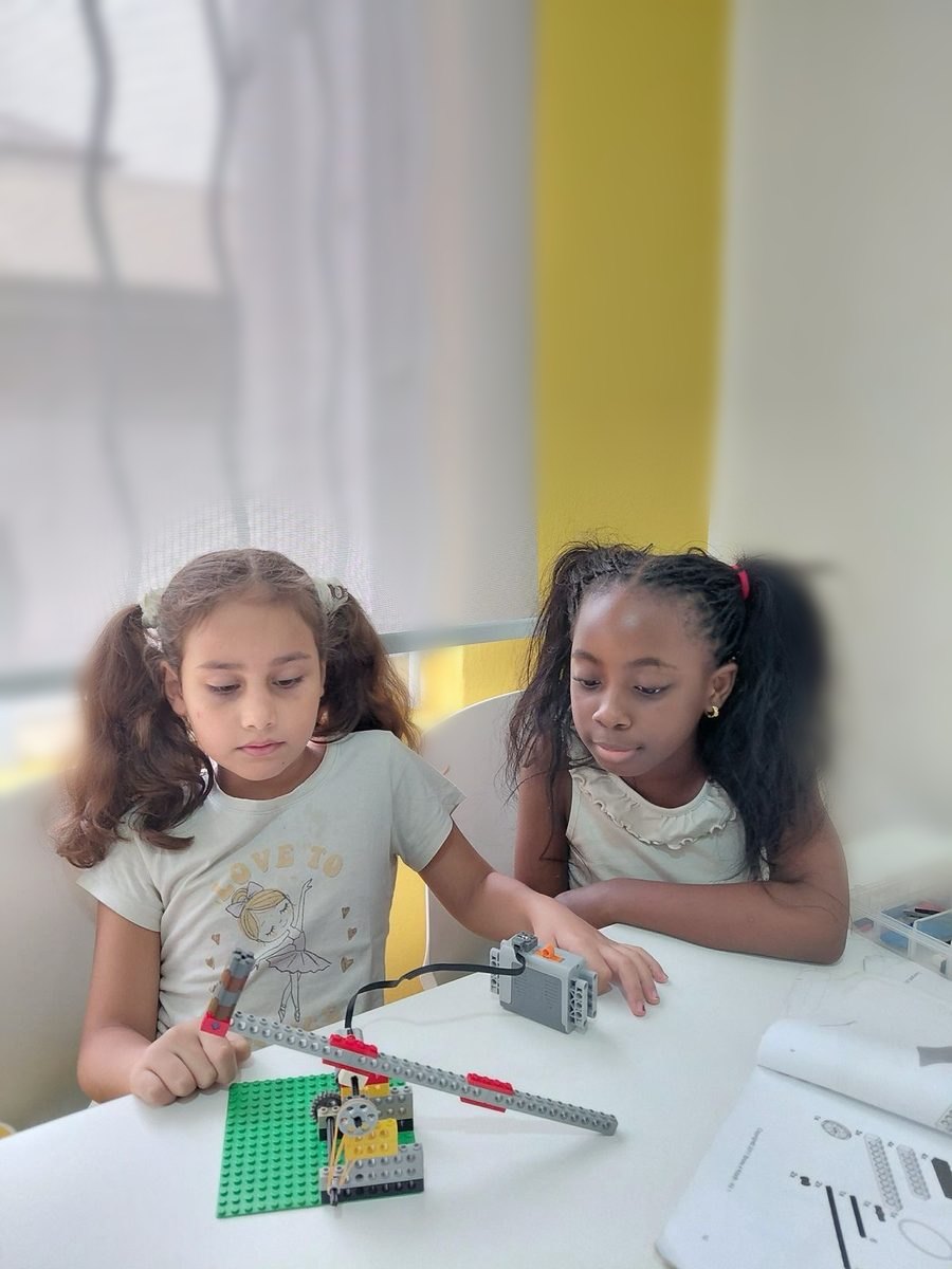 Two girls at The MakerSpace building and testing a motorised LEGO model together